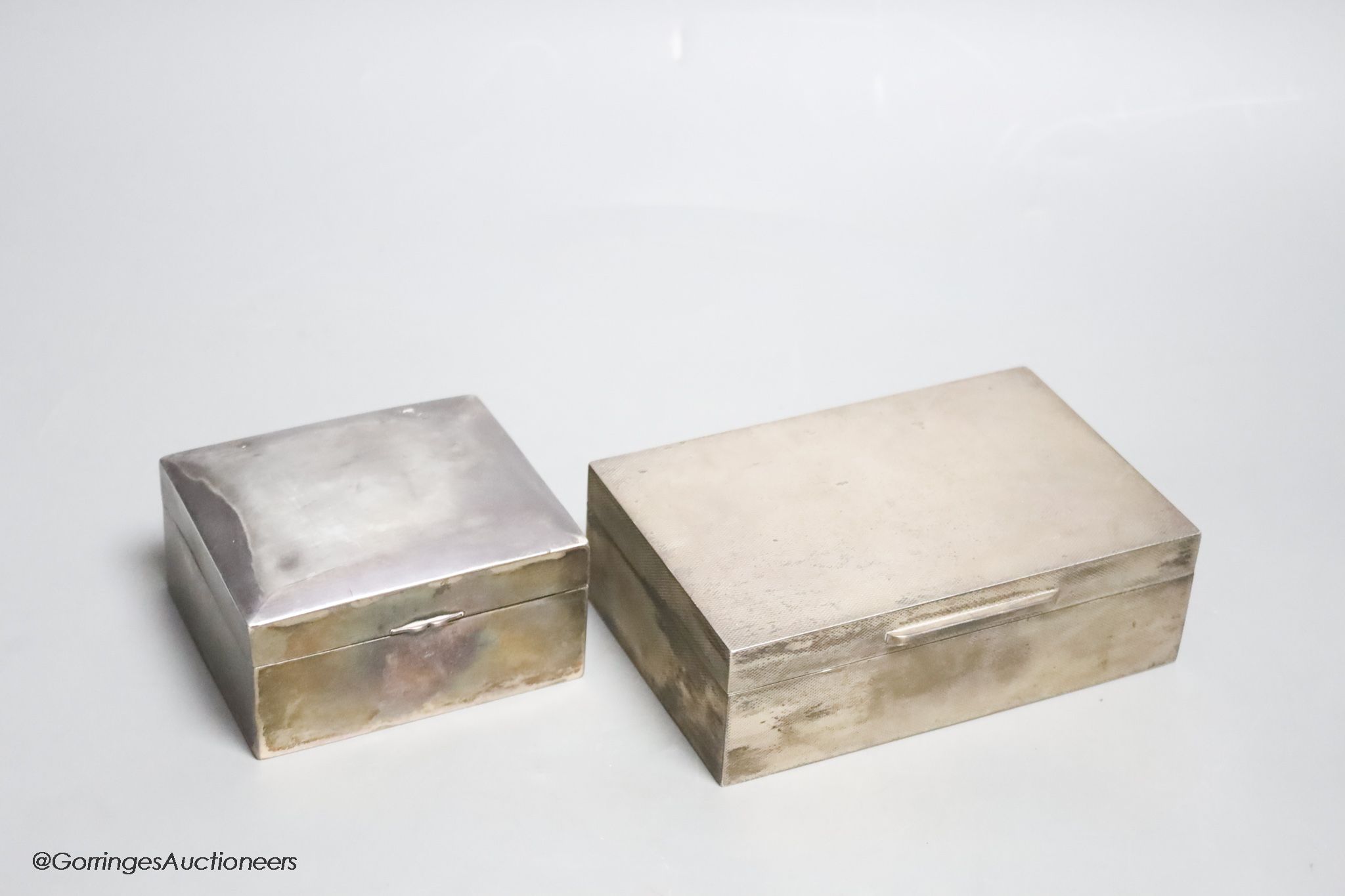 A 1950's engine turned silver cigarette box by Asprey & Co, 14cm and a sterling cigarette box by Tientsin Yeching, 91mm